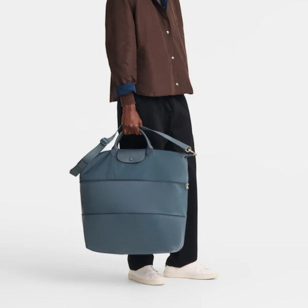 Lieblingstasche Le Pliage One travel bag in blue nylon with leather trim, held by a man.