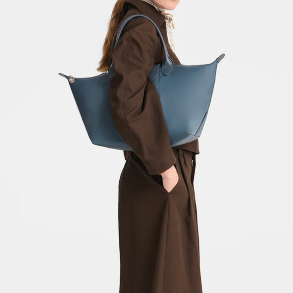 Lieblingstasche Le Pliage One handbag in blue leather, worn by a model.