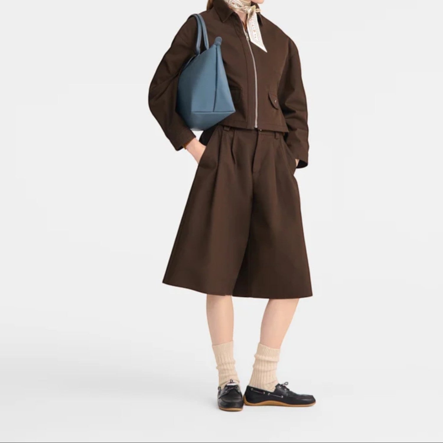 Lieblingstasche Le Pliage One Handtasche L, a blue leather tote bag with top handles, worn by a model in a brown outfit.