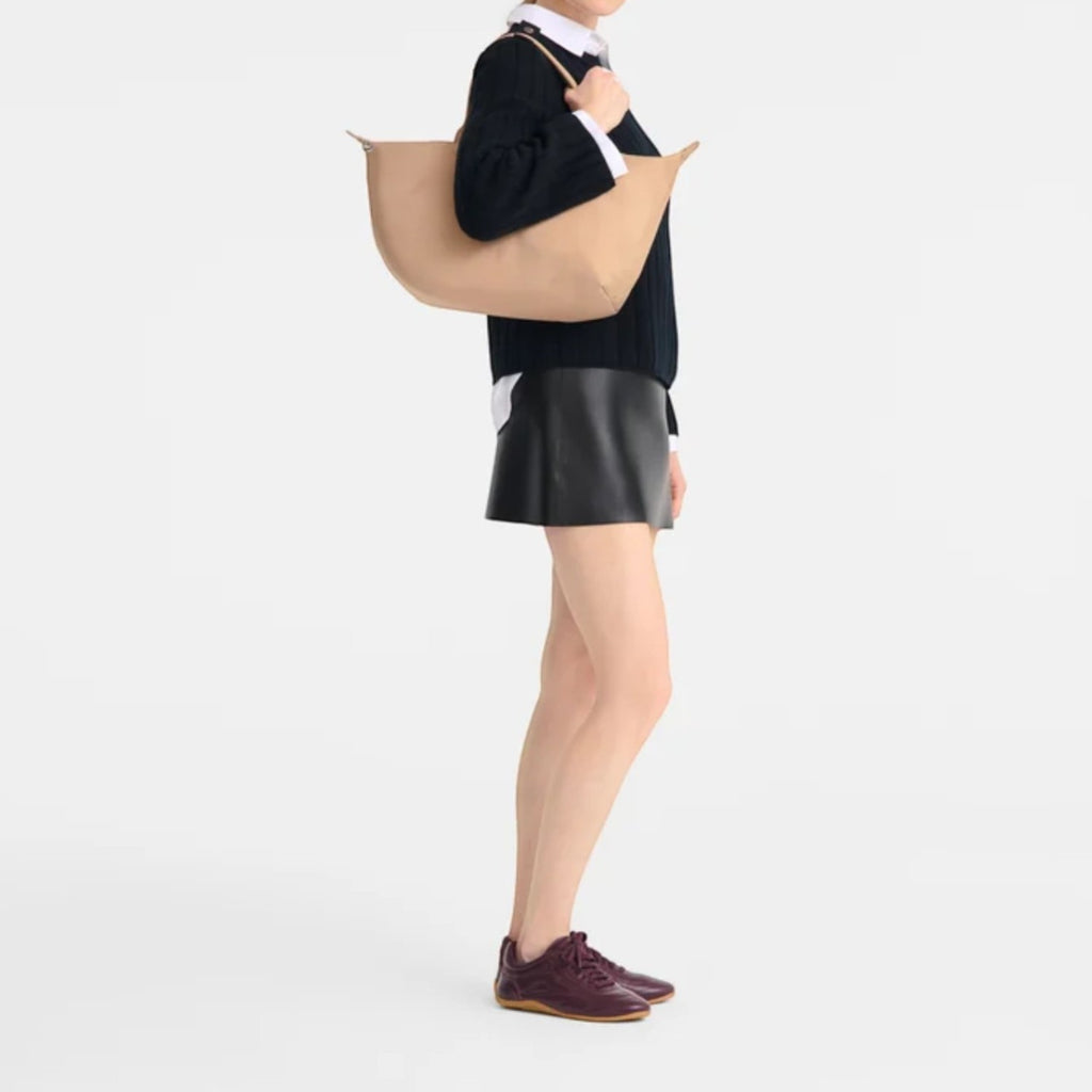 Lieblingstasche Le Pliage One Handtasche L tote bag in tan leather, worn by a model in a studio.