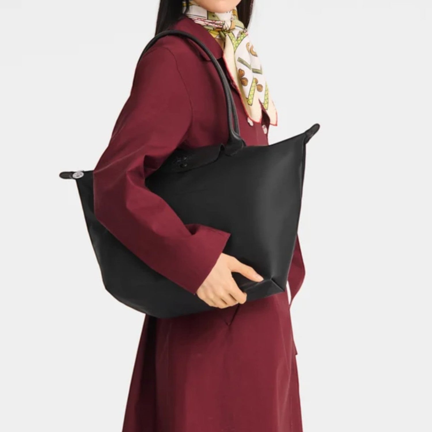 Lieblingstasche Le Pliage One L black nylon tote bag with leather handles and a snap closure, worn by a model.