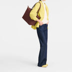 Lieblingstasche Le Pliage One L shoulder bag in burgundy nylon with leather trim, worn by a model.