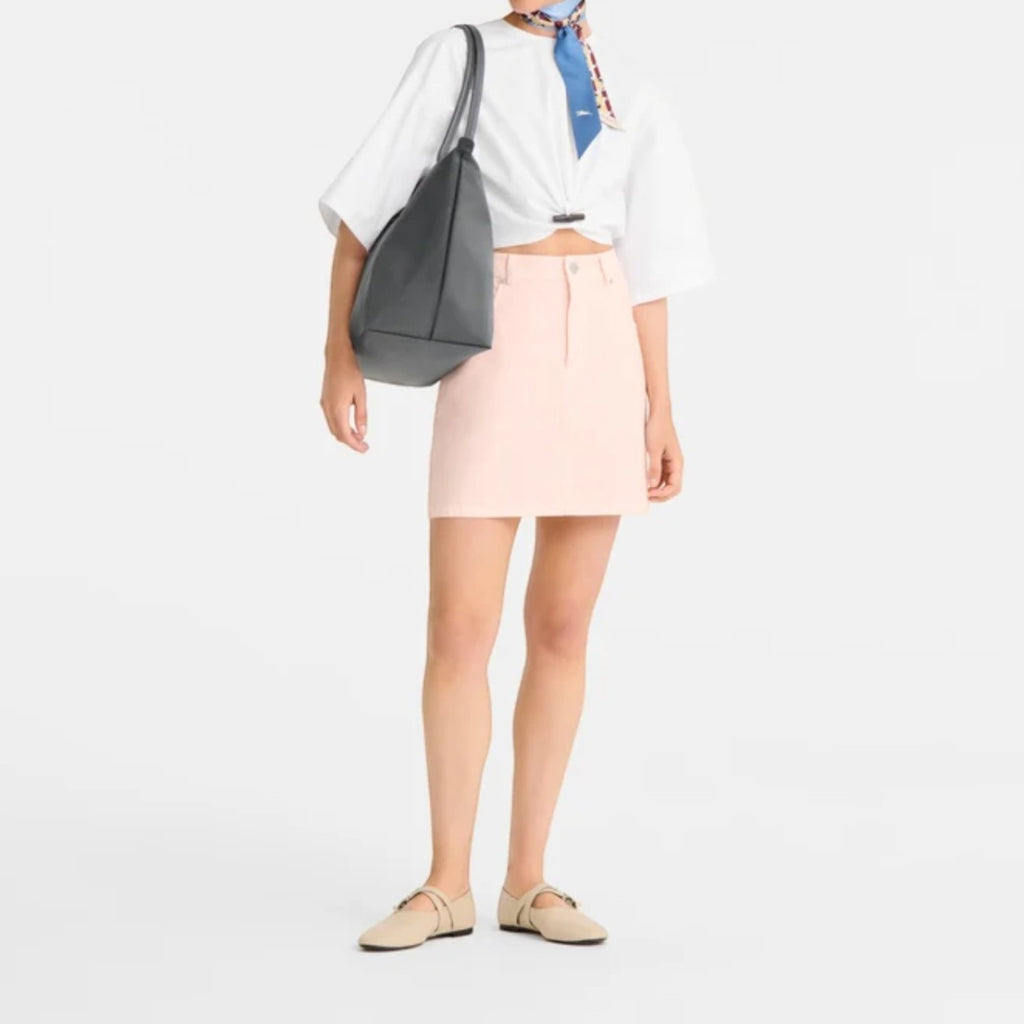 Lieblingstasche Le Pliage One L shoulder bag in dark grey leather with a white knotted top and pink denim skirt.
