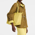Lieblingstasche Le Pliage One L shoulder bag in bright yellow nylon with leather handles and a tan belt detail on the jacket.