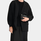 Lieblingstasche Le Pliage One Pochette in black held by a woman wearing a matching minimalist black outfit
