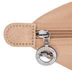 Lieblingstasche Le Pliage One Rucksack in beige nylon with leather trim and silver zipper pull featuring the Longchamp logo.