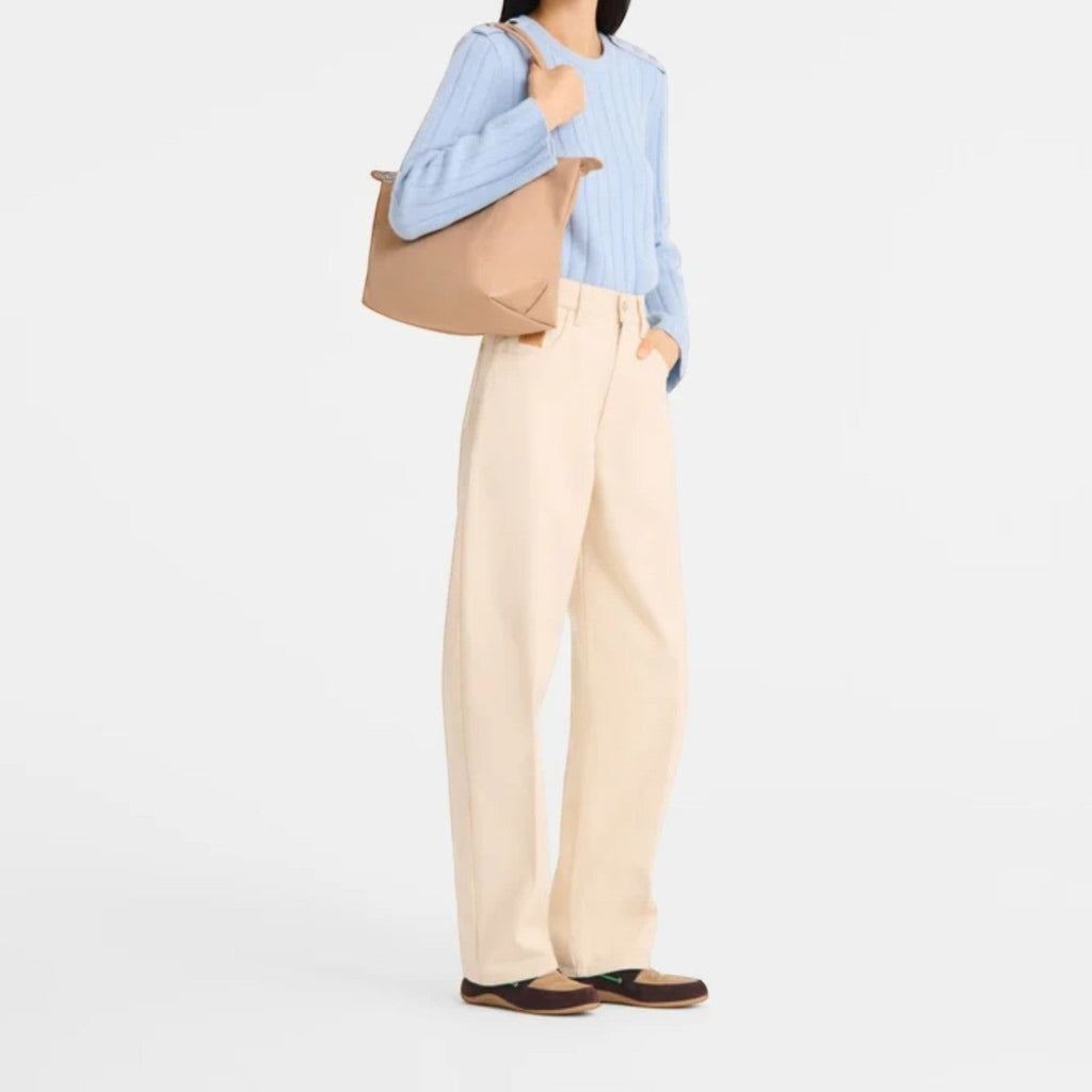 Lieblingstasche Le Pliage One M shoulder bag in beige nylon with leather trim, worn by a model.