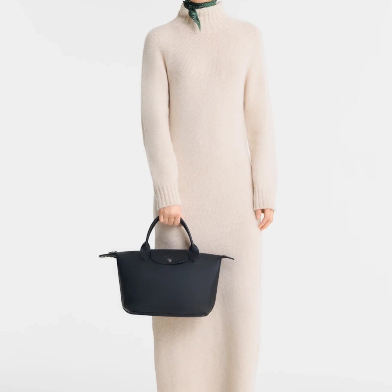Lieblingstasche Le Pliage Xtra small black leather handbag held by a model in a cream knit dress