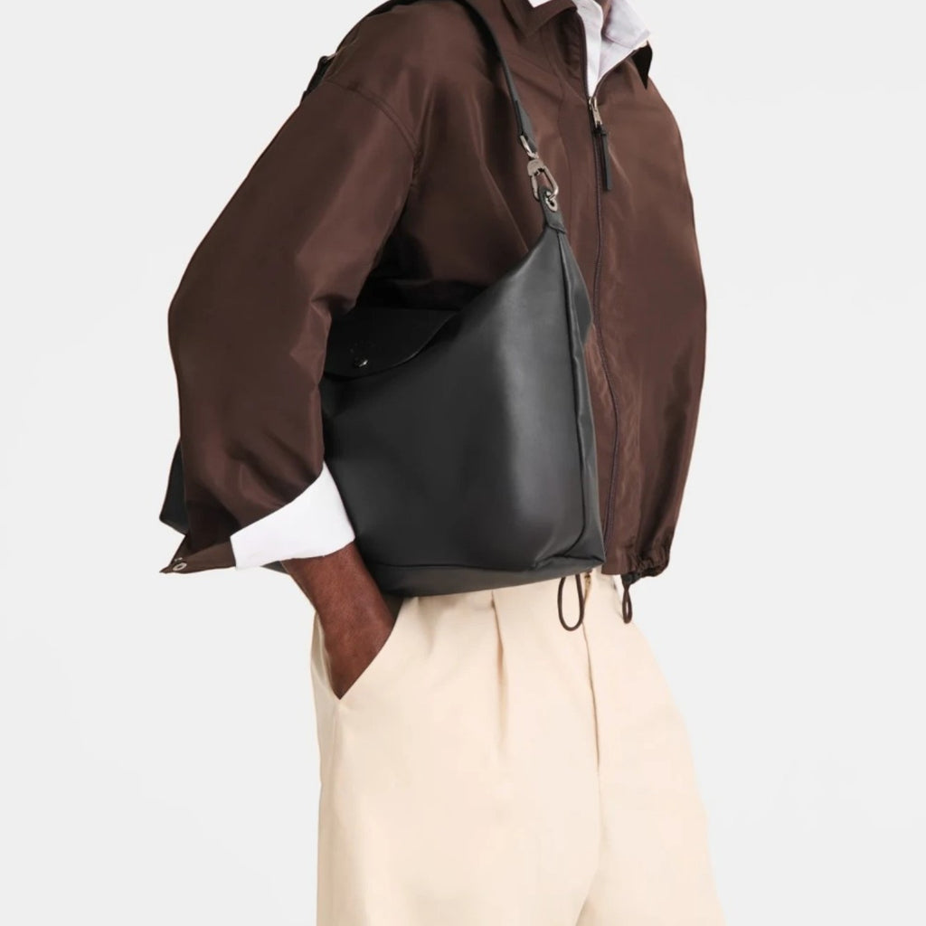 Lieblingstasche Le Pliage Xtra XL black leather shoulder bag worn by a man in a brown jacket and beige trousers