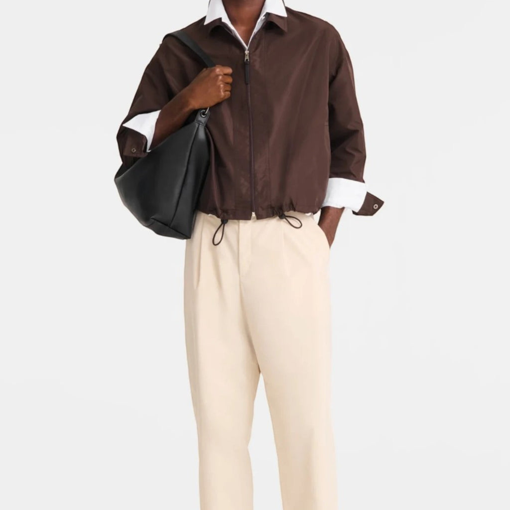 Lieblingstasche Le Pliage Xtra XL shoulder bag in black leather worn by a man in a brown jacket and beige trousers