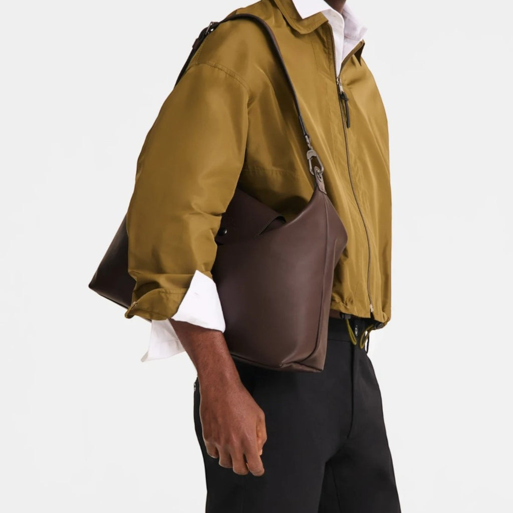 Lieblingstasche Le Pliage Xtra XL shoulder bag in dark brown leather worn by a man in a khaki jacket