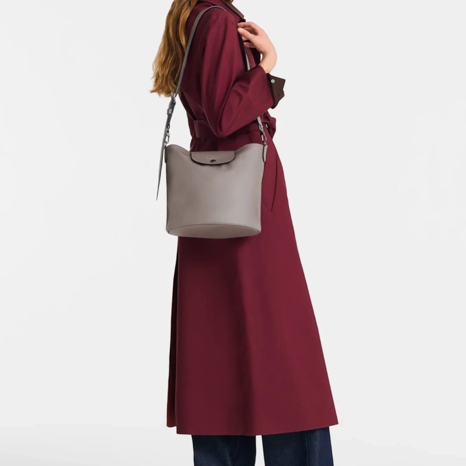 Lieblingstasche Le Pliage Xtra medium grey leather crossbody bag worn by a woman in a burgundy trench coat