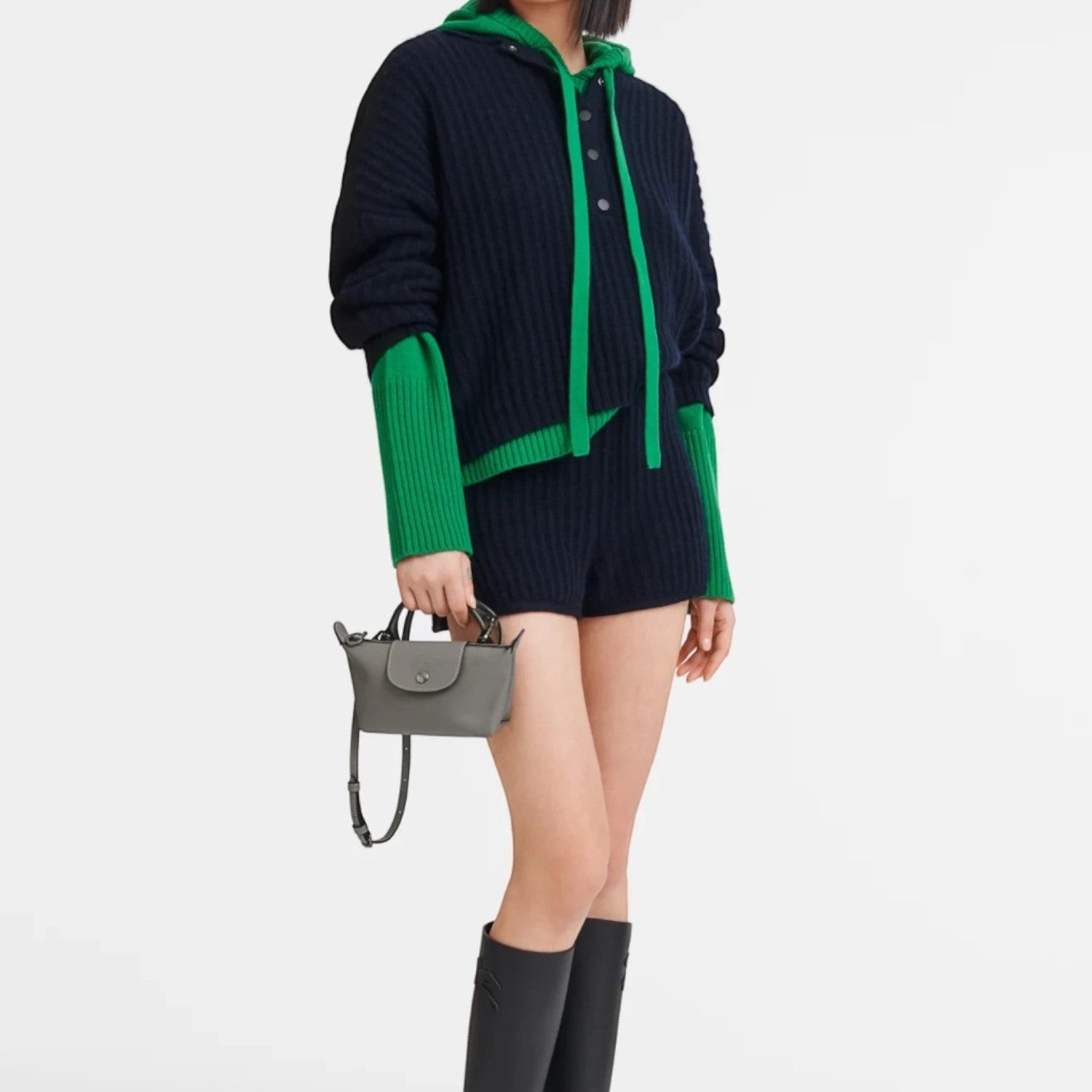 Model wearing a navy and green sweater with a grey Lieblingstasche Le Pliage Xtra pochette crossbody bag
