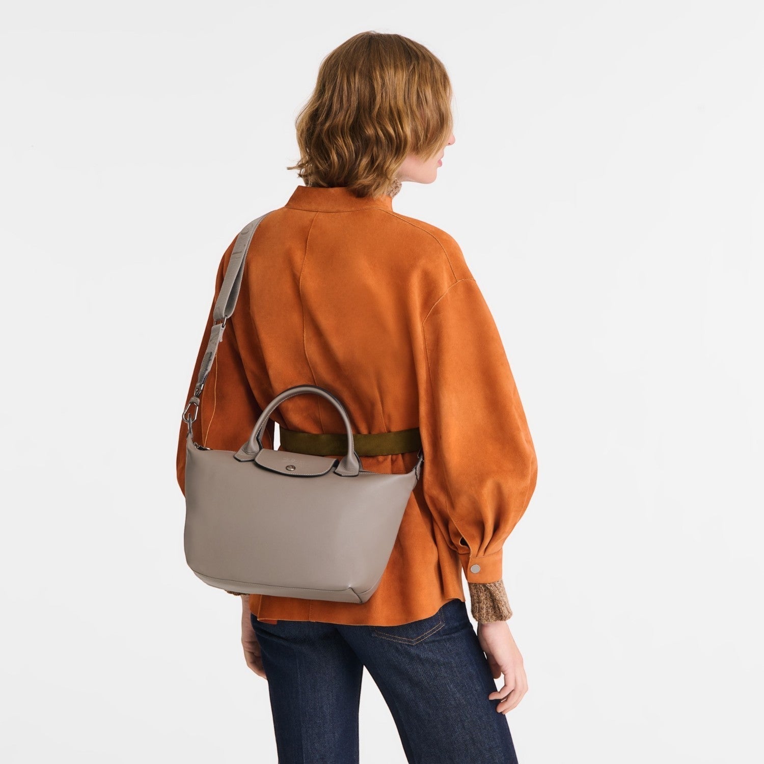 Lieblingstasche Le Pliage Xtra S handbag in taupe smooth leather worn as a shoulder bag by a woman in an orange top