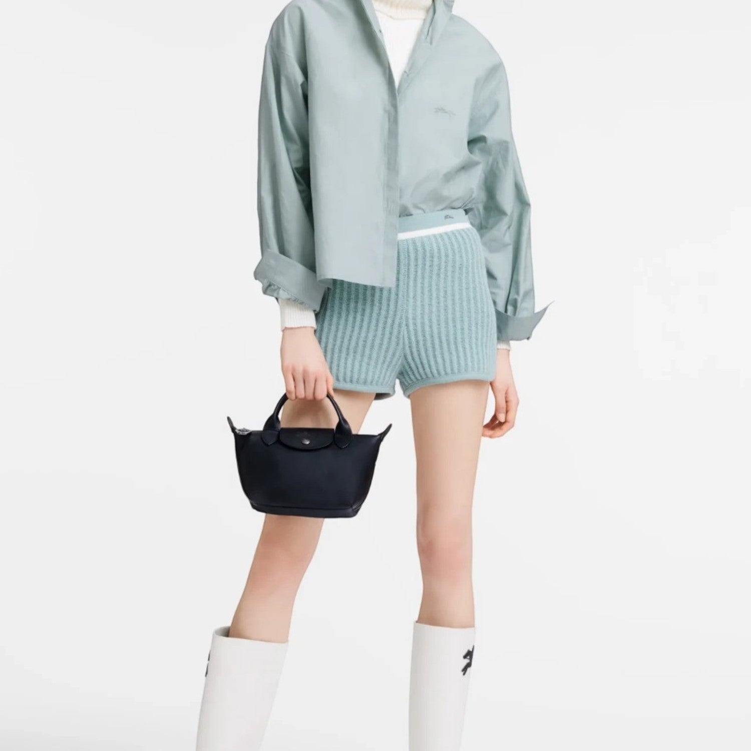 Lieblingstasche Le Pliage Xtra XS handbag in black smooth cowhide leather held by a model in a light blue outfit