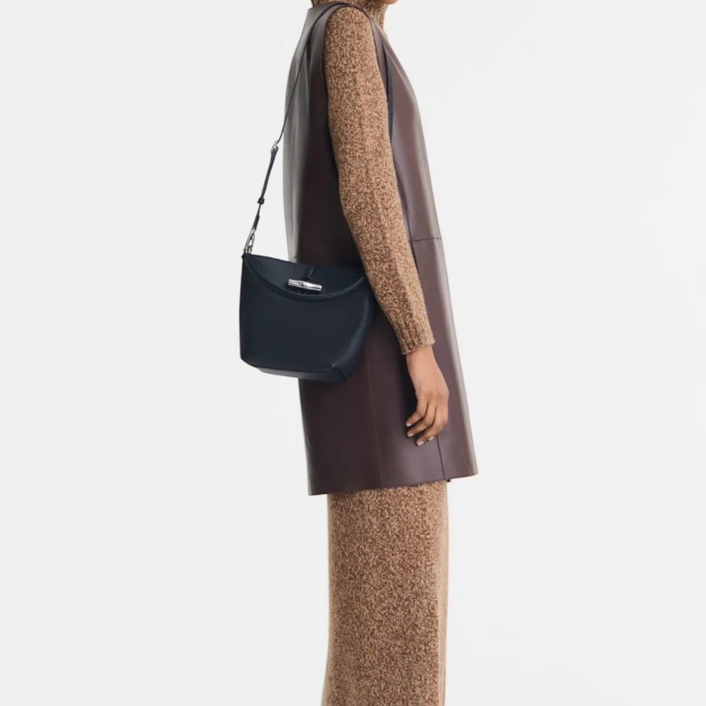 Lieblingstasche Le Roseau XS bucket bag in navy blue leather worn as a crossbody by a model in a brown outfit