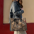 Lieblingstasche Daily Shopper bag in leopard print faux fur with black handles carried by a woman in a leather jacket