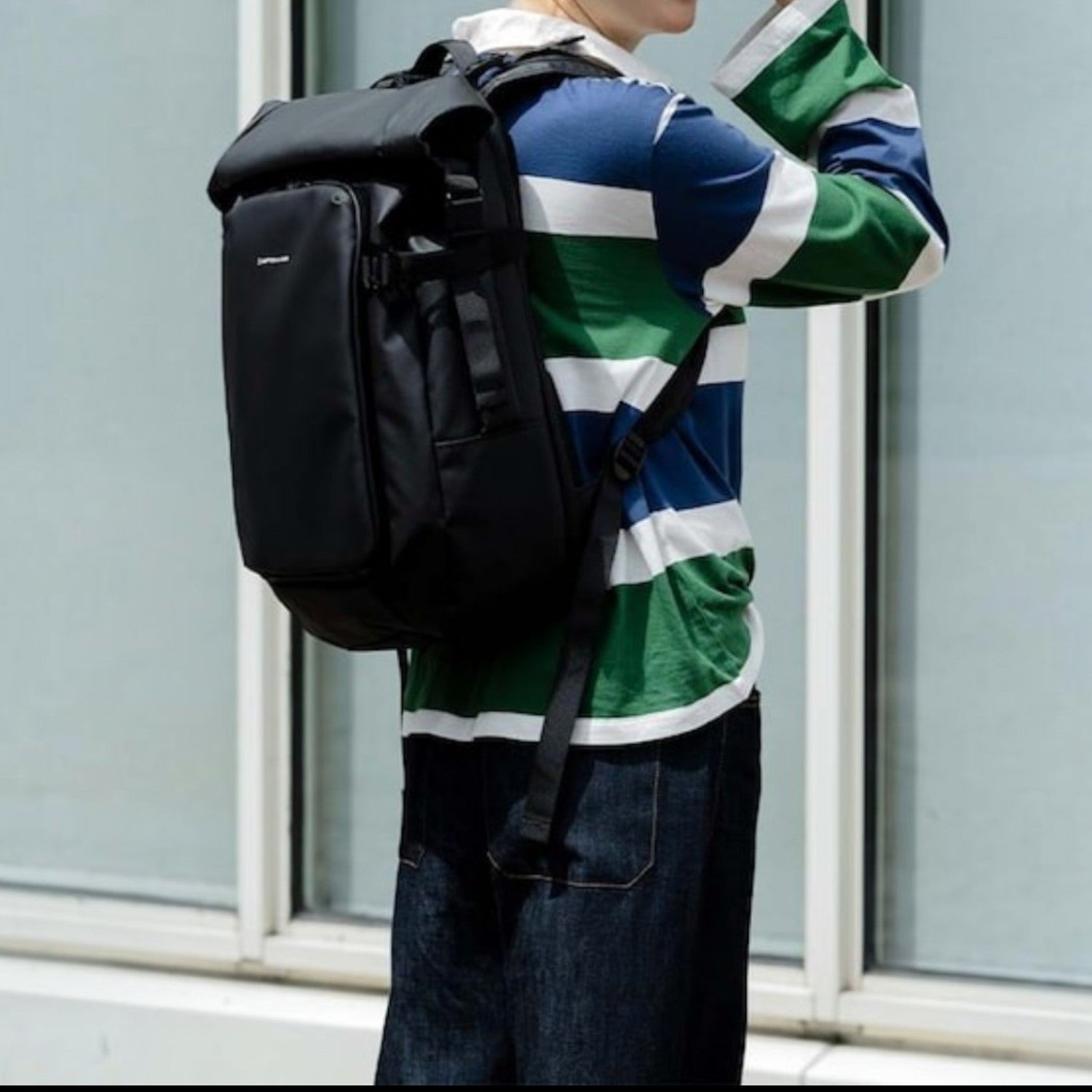 Lieblingstasche Lisbon Pro black travel backpack worn by a woman in a striped shirt outdoors