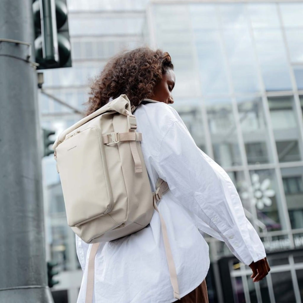 Lieblingstasche Lisbon Small beige rolltop backpack with laptop compartment worn by a woman in an urban setting
