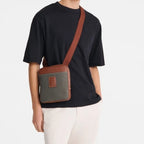 Lieblingstasche Longchamp Boxford XS crossbody bag in grey and brown canvas worn by a man in a black t-shirt