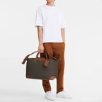 Lieblingstasche Longchamp Boxford travel bag in khaki canvas with brown leather trim held by a man in casual wear