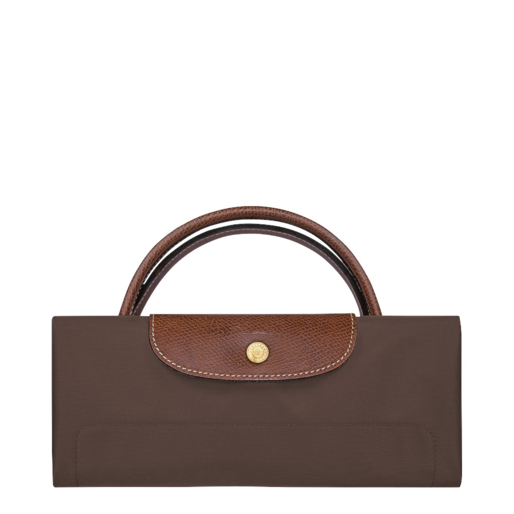 Lieblingstasche Longchamp Le Pliage travel bag in brown, folded with signature leather flap and gold snap button.