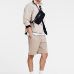 Lieblingstasche Longchamp Le Pliage Energy belt bag in black worn across the chest by a man in beige casual wear