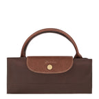 Lieblingstasche Longchamp Le Pliage XL travel bag in brown, folded into a compact shape with leather flap and gold snap.