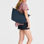 Lieblingstasche Longchamp Le Pliage large navy blue shoulder bag worn by a woman in a casual outfit