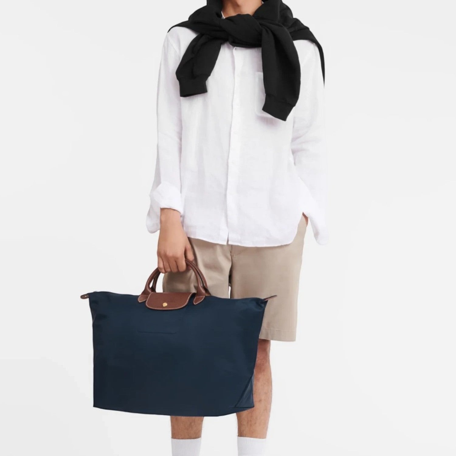 Lieblingstasche Longchamp Le Pliage large navy blue travel bag with brown leather handles held by a male model