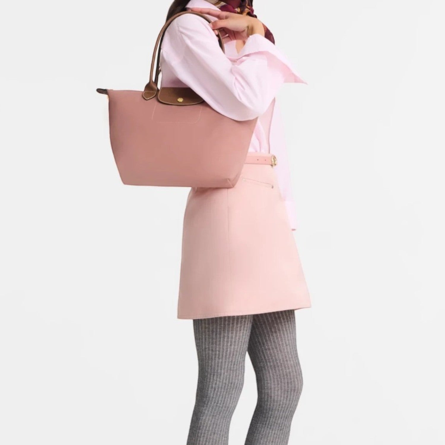 Lieblingstasche Longchamp Le Pliage medium shoulder bag in dusty pink with brown leather handles worn by a model