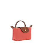 Lieblingstasche Longchamp Le Pliage Pochette in coral pink nylon with brown leather trim and gold hardware.