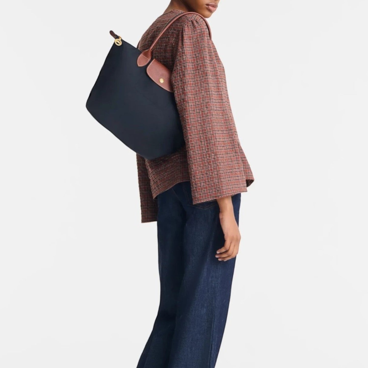 Model wearing a navy blue Longchamp Le Pliage shoulder bag with brown leather trim from Lieblingstasche
