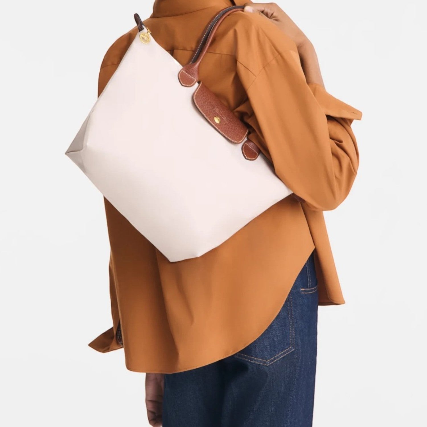 Model wearing a beige Longchamp Le Pliage medium shoulder bag with brown leather handles from Lieblingstasche
