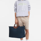 Lieblingstasche model holding a navy blue Longchamp Le Pliage XL travel bag with brown leather handles