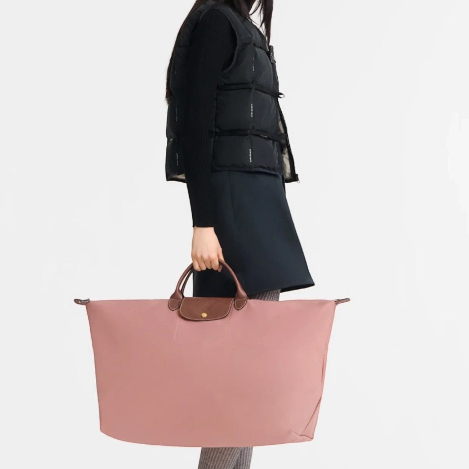 Lieblingstasche Longchamp Le Pliage XL travel bag in dusty pink with brown leather handles held by a model