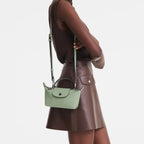 Model wearing a light green Longchamp Le Pliage Xtra leather crossbody pochette from Lieblingstasche