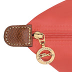 Lieblingstasche Longchamp Le Pliage shoulder bag detail featuring red nylon fabric, brown leather trim, and gold zipper