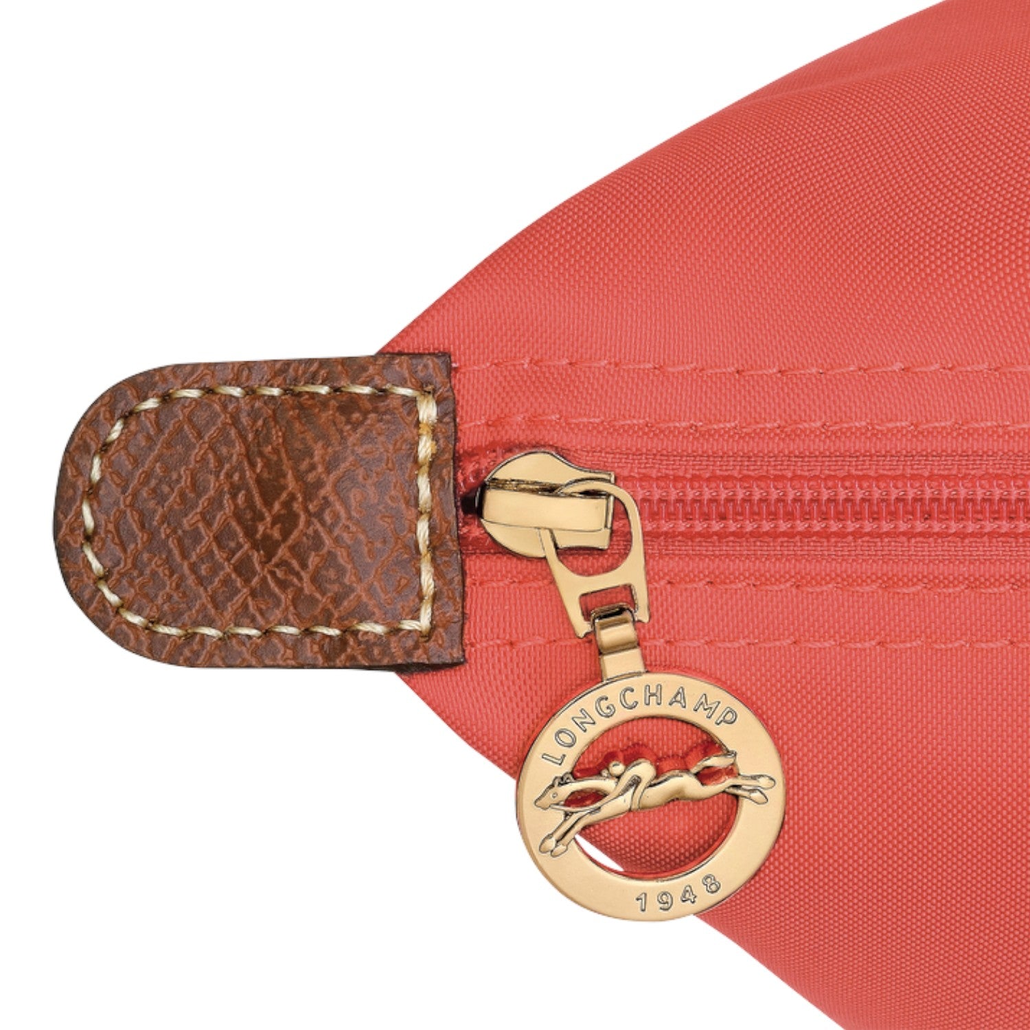 Lieblingstasche Longchamp Le Pliage shoulder bag detail featuring red nylon fabric, brown leather trim, and gold zipper