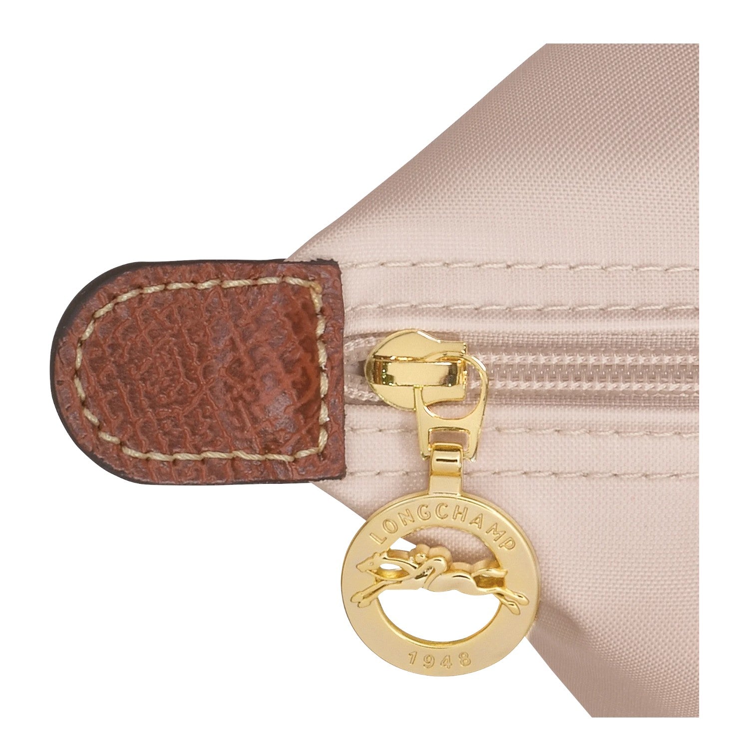 Lieblingstasche Longchamp Le Pliage shoulder bag detail showing beige nylon fabric, brown leather trim, and gold zipper