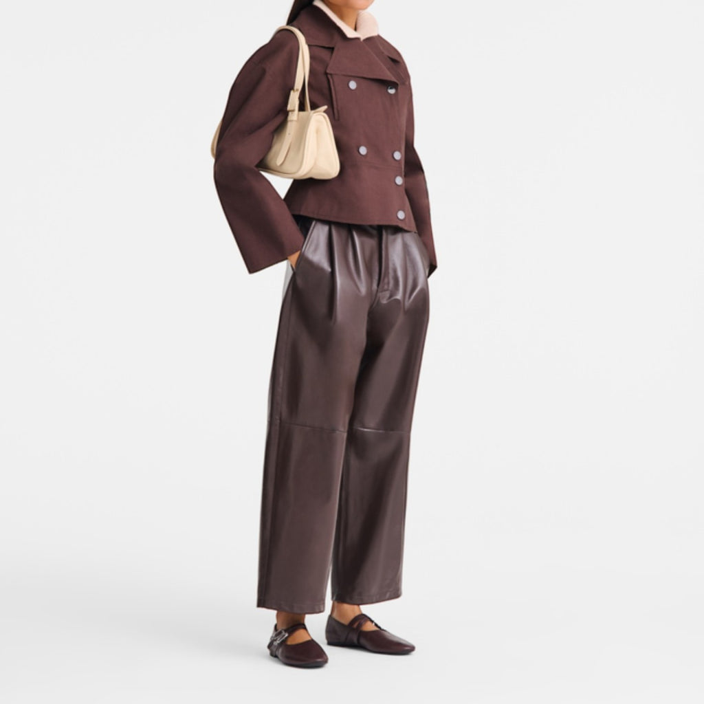 Lieblingstasche Looong shoulder bag in cream leather worn by a model in a brown jacket and leather trousers