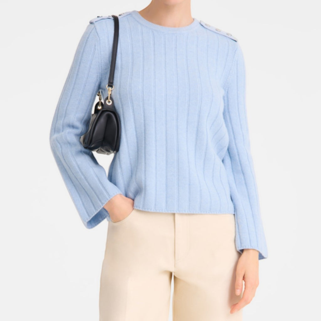 Lieblingstasche Looong Schultertasche S in black leather worn by a model in a light blue ribbed sweater