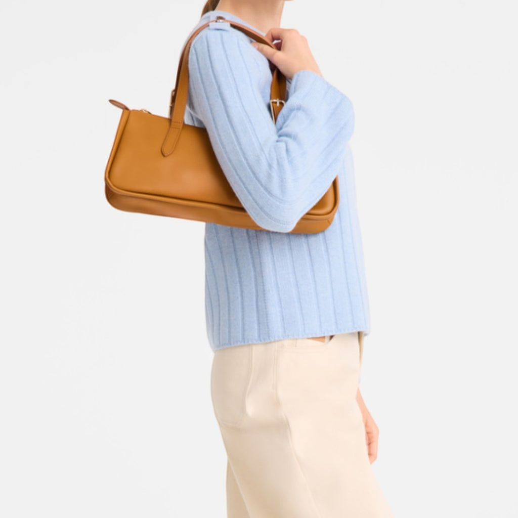 Lieblingstasche Looong shoulder bag in tan leather with a slim rectangular silhouette carried by a woman