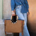 Lieblingstasche Loopshopper L brown suede tote bag with fringe details and rounded wooden handles held by a woman
