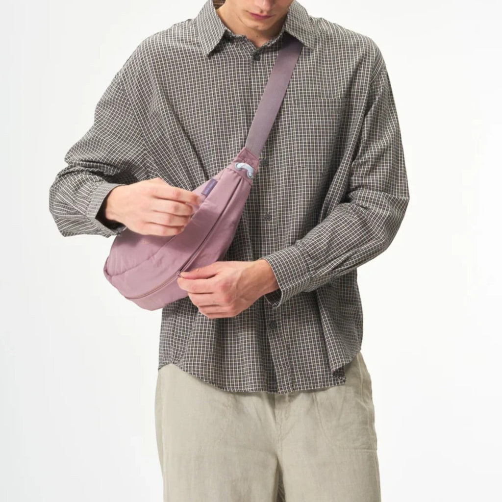 Lieblingstasche mauve sling bag worn crossbody by a man in a plaid shirt and baseball cap