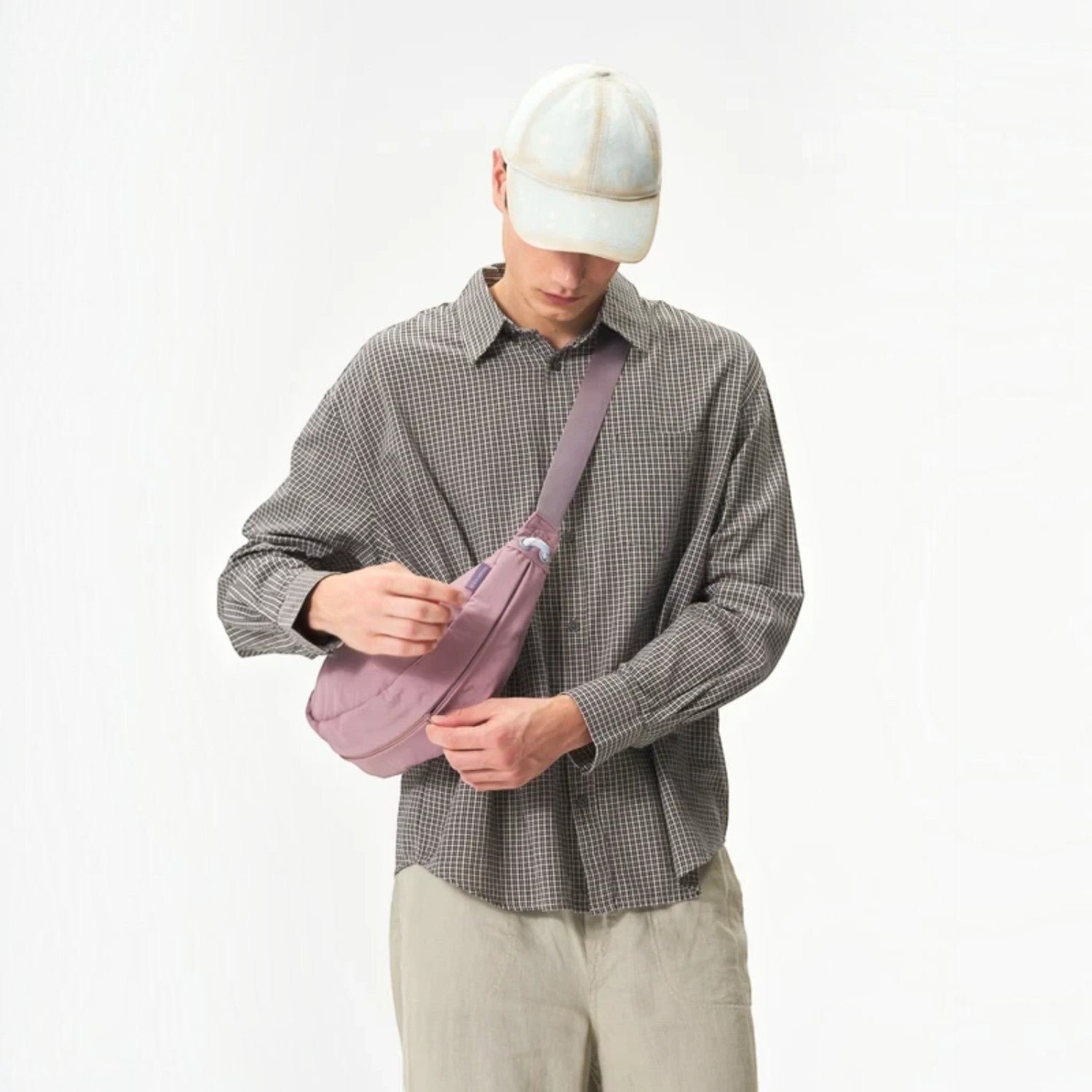 Lieblingstasche mauve water-resistant sling bag worn crossbody by a man in a checkered shirt and baseball cap