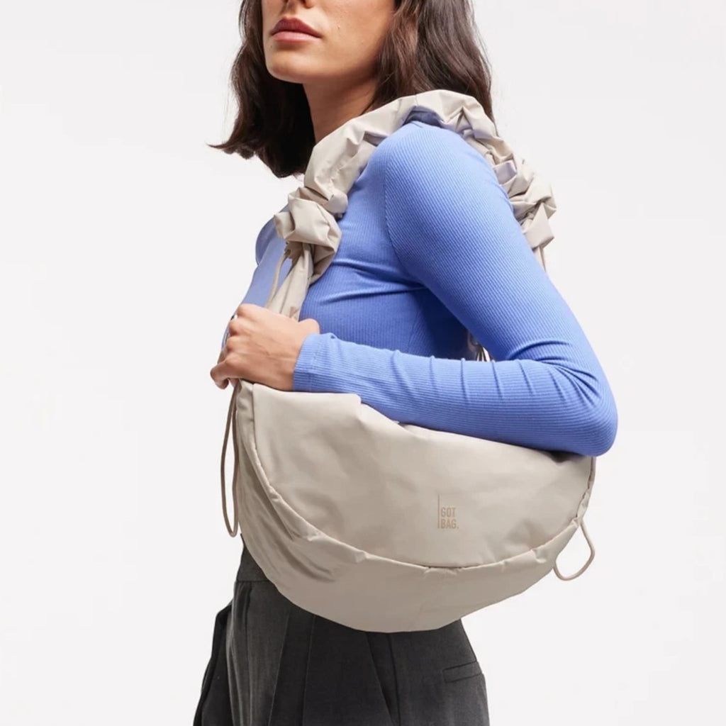 Lieblingstasche Moon Bag Ruffle Large in beige, worn as a shoulder bag with a gathered strap and water-resistant finish.