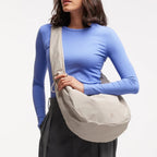 Lieblingstasche Moon Bag Ruffle Large in beige, worn as a crossbody bag by a model in a blue long-sleeve top.