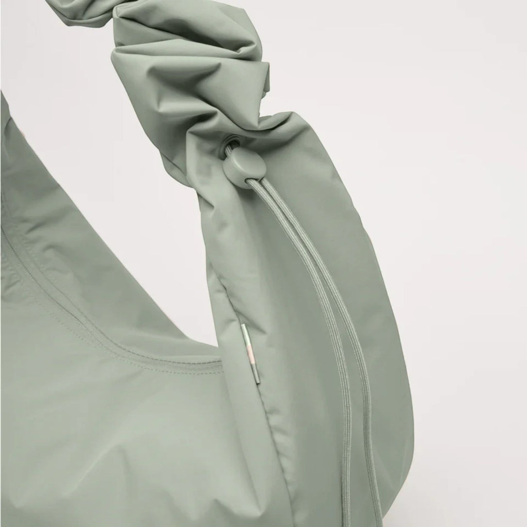 Lieblingstasche Moon Bag Ruffle Large in sage green made from recycled fishing nets with a gathered strap detail.