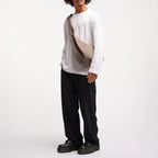 Lieblingstasche Moon Bag Ruffle Large in beige, worn as a crossbody bag by a man in a white long-sleeve shirt.